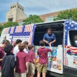 Ice cream truck serving graduates during outdoor celebration