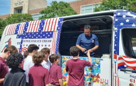 Ice cream truck serving graduates during outdoor celebration