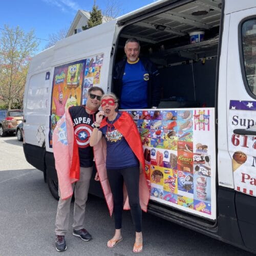Kids and adults enjoying ice cream from a colorful ice cream truck at a lively party in Massachusetts